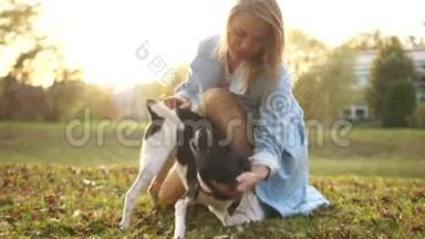 年轻女子和她的狗在<strong>秋天</strong>公园散步。 那条狗在发抖。 <strong>黑白</strong>混血